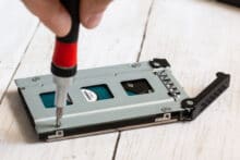 Die Festplatte wird am Caddy verschraubt