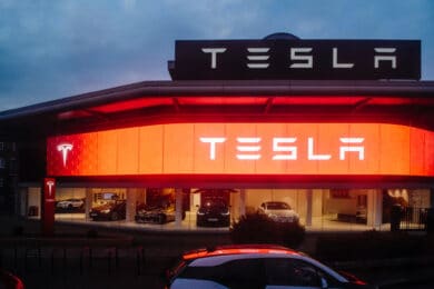 Tesla motors showroom with cars inside and illuminated logo bran
