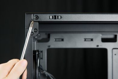 Eine Schraube wird mit dem Schraubenzieher aus dem Gehäuse entfernt