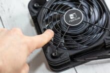 Finger auf dem Lüftergitter des Noctua NV-FS2 im Test