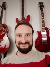 Mann und Gitarren im Hintergrund