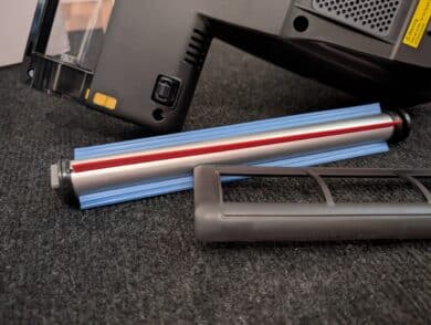 Entnommene Bürstenwalze mit Abdeckung neben dem Gerät