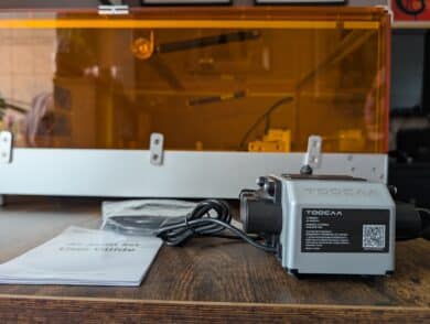 TOCOAA Air Assist Pumpe mit Anleitung vor dem geschlossenen Lasergehäuse.