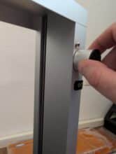 Montage der Standfüße am Rahmen des Toocaa L2 mit Hand