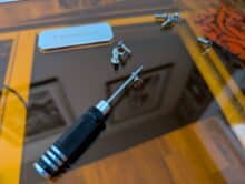 Schraubendreher und Schrauben auf dem Toocaa L2 – mitgeliefertes Werkzeug auf der Acrylklappe während des Aufbaus