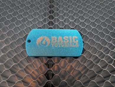 Graviertes Aluminium-Dogtag mit „BASIC TUTORIALS“-Logo auf Wabenplatte