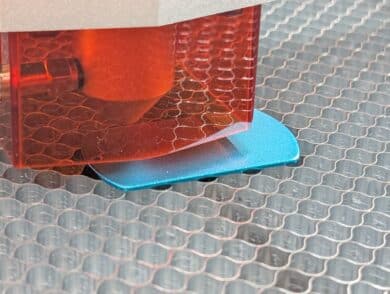 Laserkopf über blauem Dogtag – Gravurvorgang kurz unterbrochen