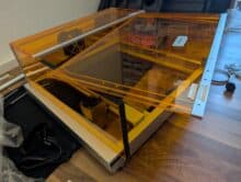 Toocaa L2 während der Montage – Acrylklappe lose aufgelegt, Aufkleber zur Ausrichtung sichtbar, Zubehör liegt bereit