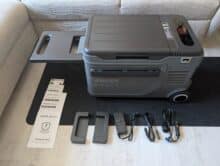 Anker Solix EverFrost 2 23L mit ausgeklapptem Tisch, Zubehör und Anleitungen nebeneinander auf dem Boden