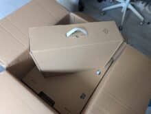 Entnommene Zubehörbox mit Kunststoffgriff im Karton