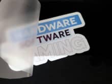 Teilweise abgezogene Trägerfolie mit dem Motiv HARDWARE SOFTWARE GAMING auf schwarzem Stoff